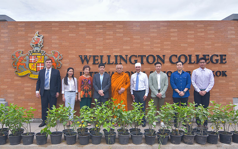 Wellington College Bangkok Dr. Darika Lathapipat, Chairman of the Board of Govenors, Shareholders, WCIB leadership team and staff in front of Wellington College sign during signage anointing ceremony.