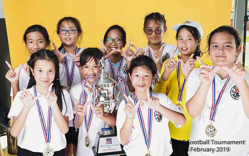 Wellington College Bangkok GBAC Football Tournament students with trophy and medals